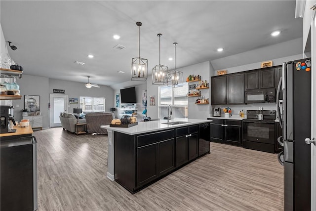 kitchen with black appliances, sink, ceiling fan, an island with sink, and light hardwood / wood-style floors