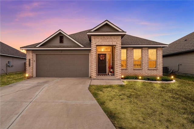 view of front of home with central AC, a yard, and a garage