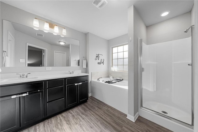 bathroom featuring hardwood / wood-style floors, vanity, and plus walk in shower