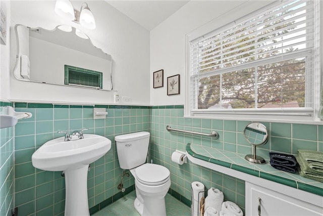 bathroom featuring tile walls and toilet