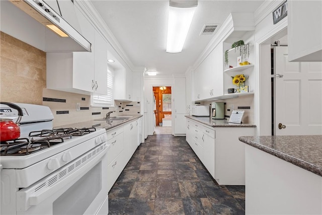 kitchen with tasteful backsplash, sink, white cabinets, and white appliances