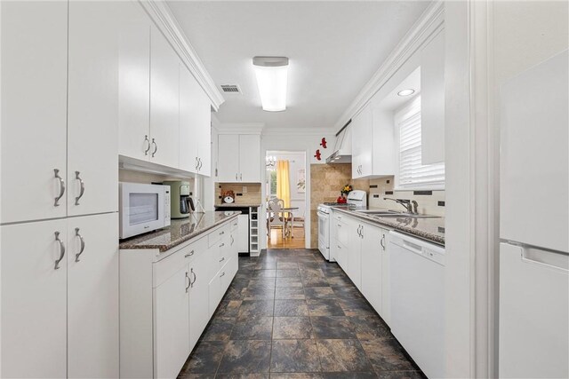 kitchen with wall chimney range hood, white cabinetry, sink, and white appliances