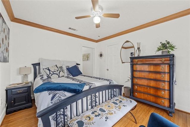 bedroom with light wood-type flooring, ceiling fan, and ornamental molding