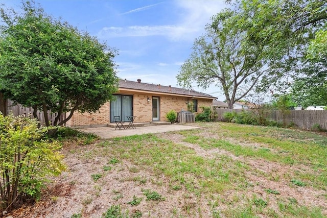 rear view of property featuring a yard and a patio area