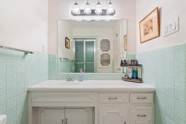 bathroom with vanity, tile walls, and walk in shower