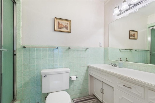 bathroom with vanity, crown molding, toilet, tile walls, and walk in shower