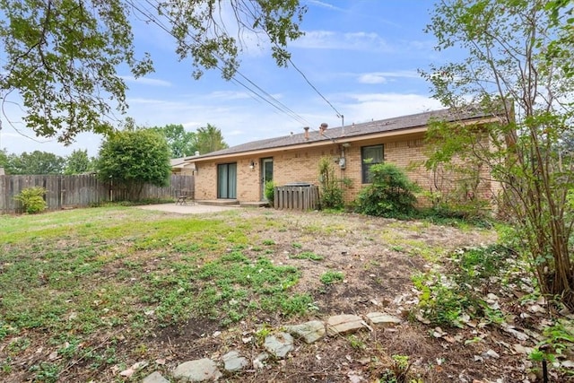 back of house with a patio area and a yard