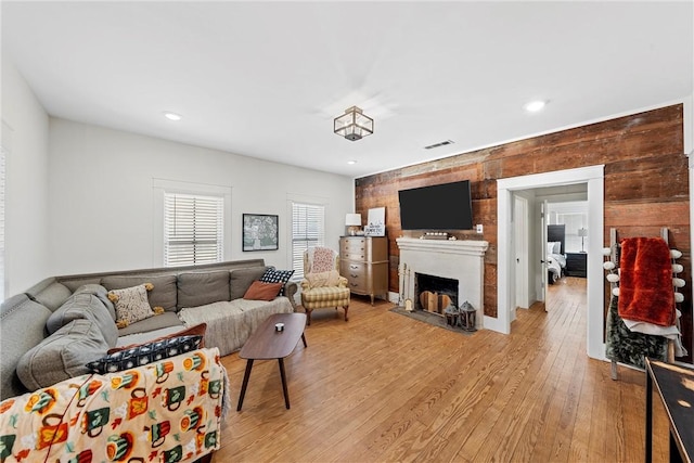 living room featuring wood walls and light wood-type flooring