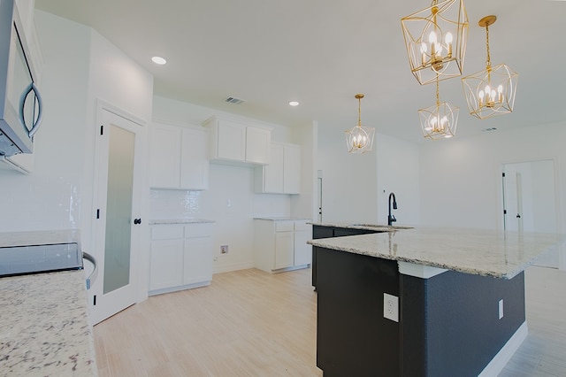 kitchen featuring light hardwood / wood-style flooring, white cabinets, and pendant lighting