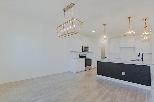 kitchen with stainless steel appliances, white cabinetry, hanging light fixtures, and light stone counters