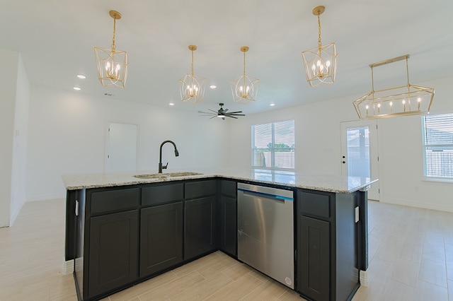 kitchen featuring light stone countertops, ceiling fan, decorative light fixtures, dishwasher, and an island with sink