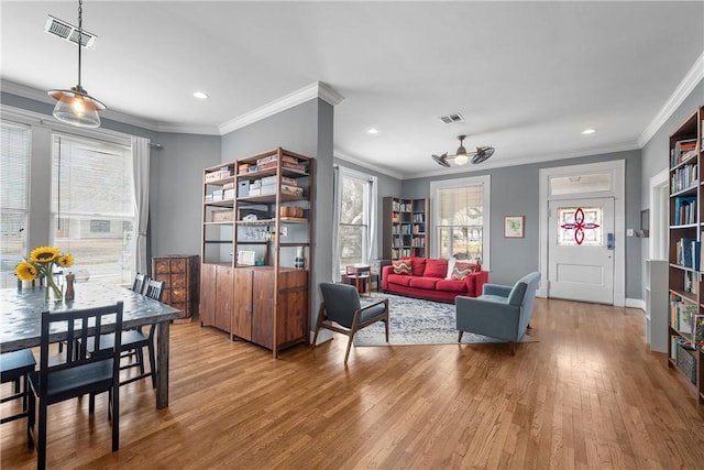 living area featuring recessed lighting, visible vents, wood finished floors, and crown molding