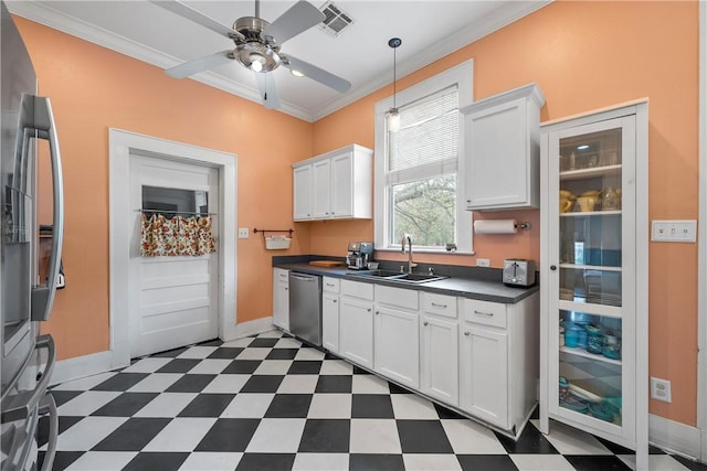 kitchen featuring a sink, dark countertops, appliances with stainless steel finishes, dark floors, and crown molding