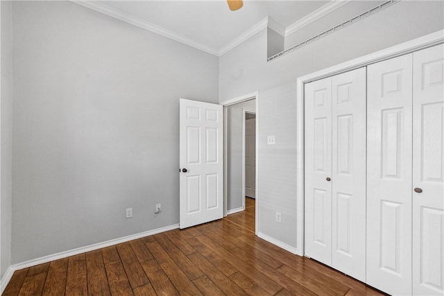 unfurnished bedroom featuring ceiling fan, dark hardwood / wood-style floors, crown molding, and a closet