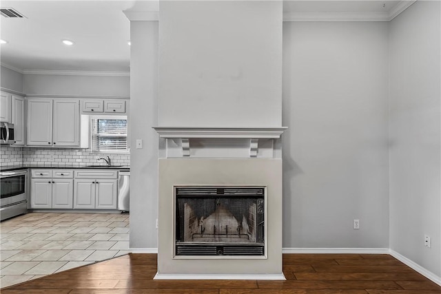 interior space featuring white cabinetry, sink, appliances with stainless steel finishes, and tasteful backsplash