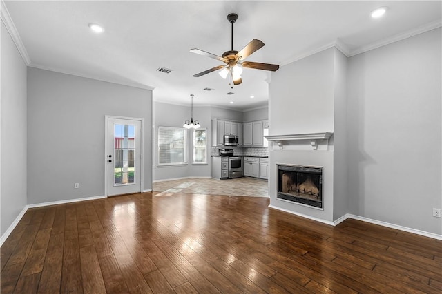 unfurnished living room featuring hardwood / wood-style floors, ceiling fan with notable chandelier, and ornamental molding