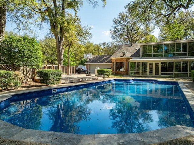 view of swimming pool featuring a sunroom