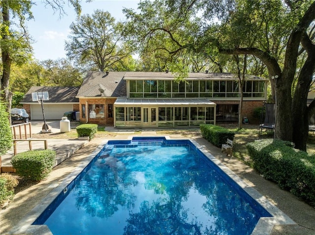 exterior space with a trampoline and a sunroom