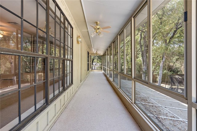 unfurnished sunroom with ceiling fan