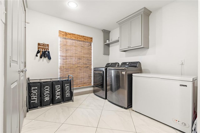 washroom with cabinets and washer and dryer