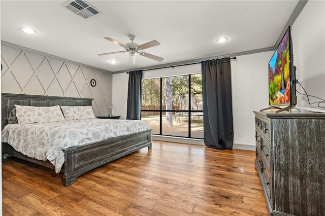 bedroom with light hardwood / wood-style flooring, ceiling fan, and ornamental molding