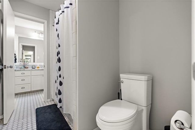 bathroom featuring tile patterned flooring, a shower with curtain, vanity, and toilet