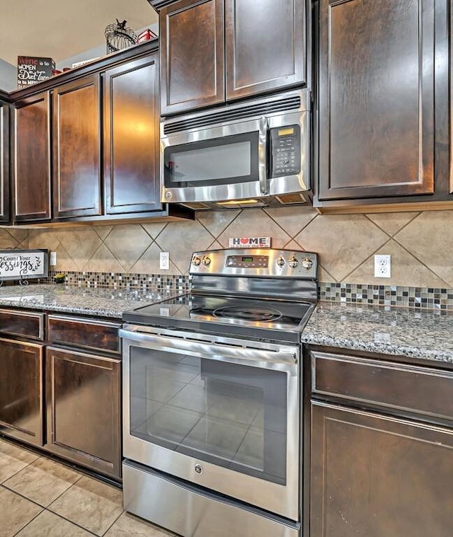 kitchen featuring decorative backsplash, dark brown cabinets, light tile patterned floors, and appliances with stainless steel finishes