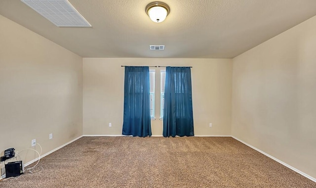 spare room featuring carpet and a textured ceiling