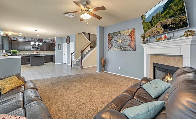 carpeted living room featuring a fireplace and ceiling fan