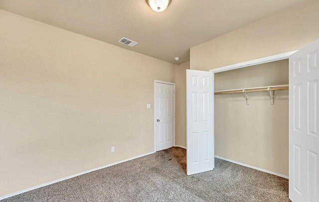 unfurnished bedroom featuring carpet flooring and a closet