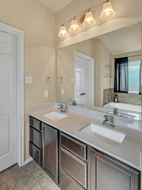 bathroom featuring a washtub, vanity, and tile patterned floors