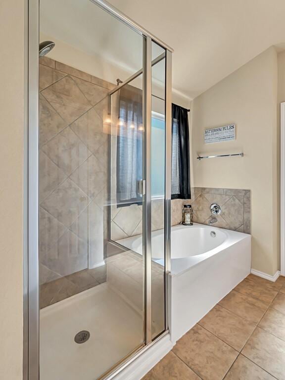 bathroom featuring tile patterned floors, lofted ceiling, and independent shower and bath