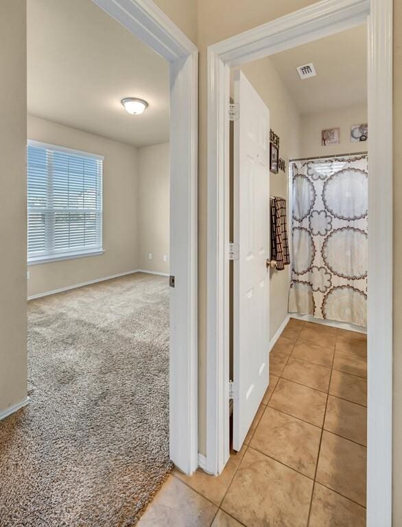 corridor featuring light colored carpet