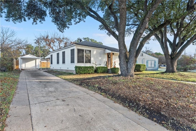 single story home with a front yard, a garage, and an outdoor structure