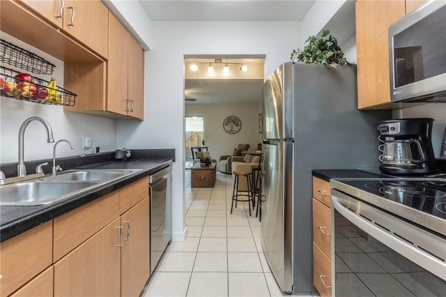 kitchen with light tile patterned flooring, sink, and appliances with stainless steel finishes