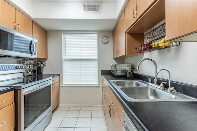 kitchen featuring light tile patterned floors, stainless steel appliances, and sink