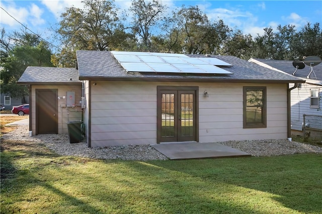 back of house featuring solar panels, a yard, and french doors