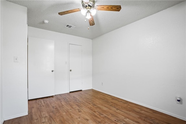 unfurnished bedroom featuring ceiling fan, a textured ceiling, and hardwood / wood-style flooring