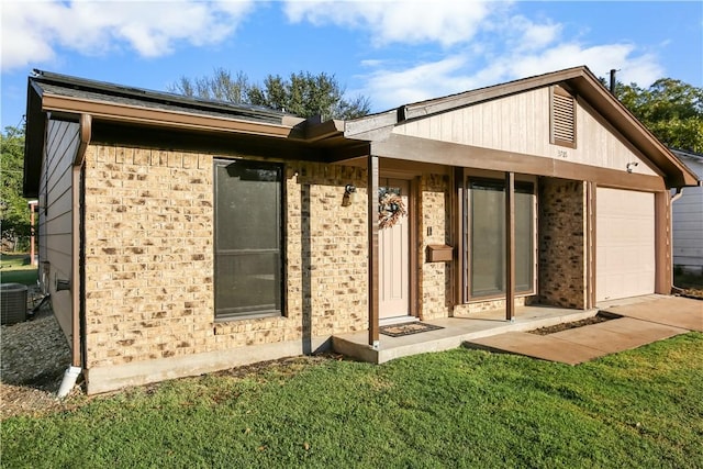 rear view of property with a garage and a lawn