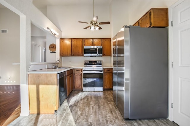 kitchen featuring ceiling fan, sink, stainless steel appliances, and hardwood / wood-style flooring