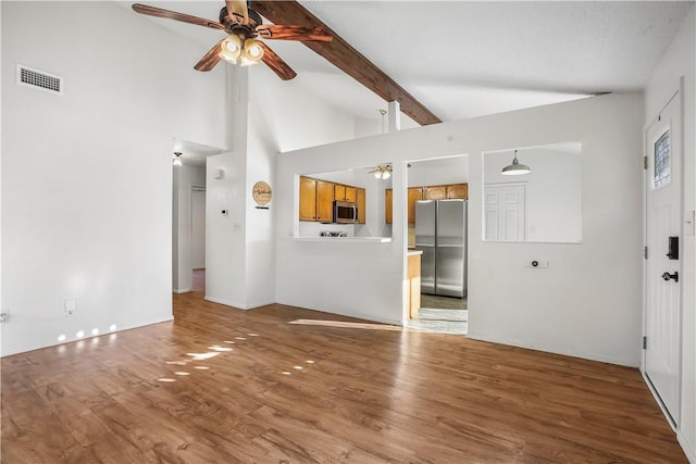 unfurnished living room with beam ceiling, ceiling fan, hardwood / wood-style floors, and high vaulted ceiling