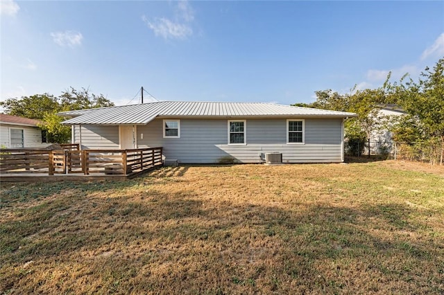 back of house featuring central AC unit and a yard