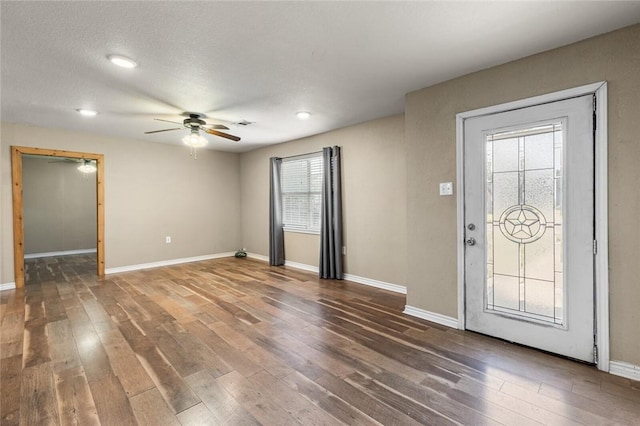 entrance foyer with ceiling fan, dark hardwood / wood-style flooring, and a textured ceiling