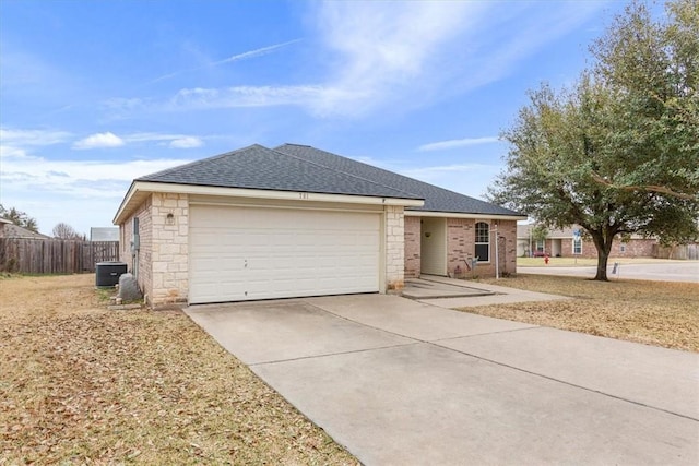 ranch-style home featuring an attached garage, a shingled roof, fence, and concrete driveway