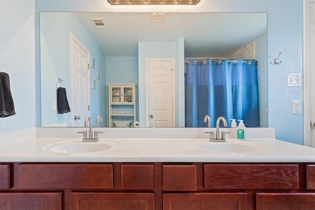 full bath featuring visible vents, a sink, and double vanity