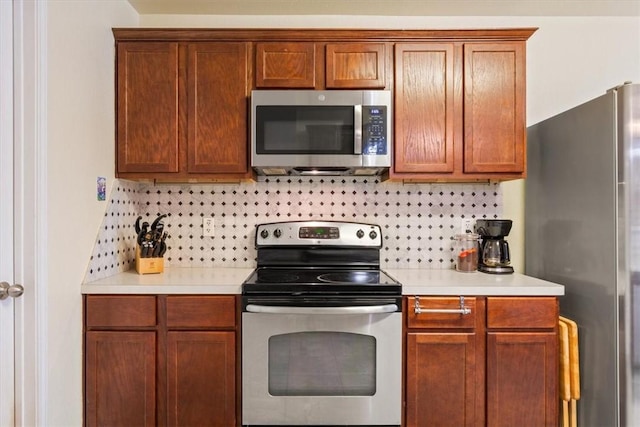 kitchen featuring brown cabinets, appliances with stainless steel finishes, light countertops, and backsplash