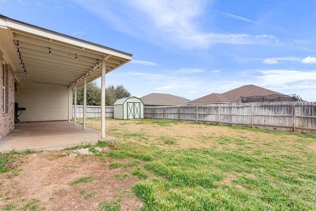 view of yard with a fenced backyard, a storage unit, an outdoor structure, and a patio