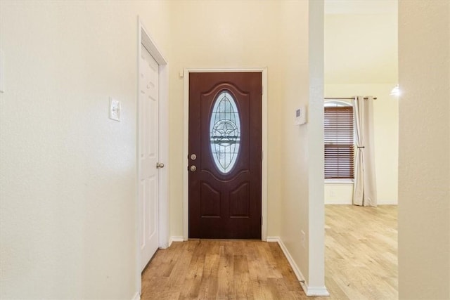 doorway with wood finished floors and baseboards