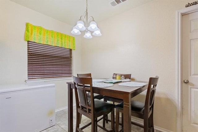 dining area featuring light tile patterned floors, visible vents, baseboards, and an inviting chandelier