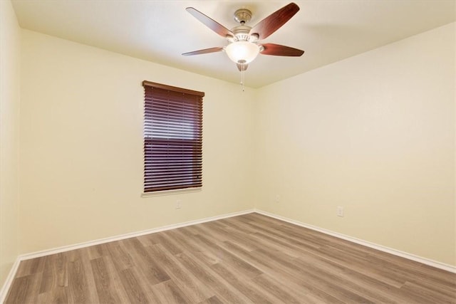 unfurnished room featuring wood finished floors, a ceiling fan, and baseboards